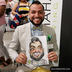 Men holding his funny cartoon at Austin trade show silly artist