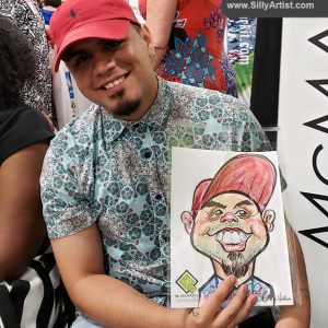 Men holding his funny cartoon at Austin trade show silly artist