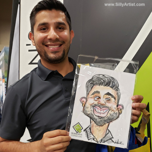 Man smiling holding his caricature at an austin trade show