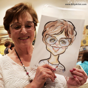 woman holding a caricature at a birthday party in Austin silly artist
