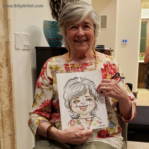woman holding a caricature at a birthday party in Austin silly artist