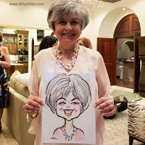 woman holding a caricature at a birthday party in Austin silly artist
