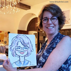 woman holding a caricature at a birthday party in Austin silly artist